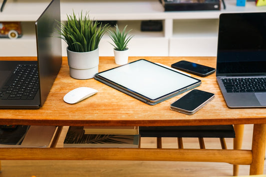 Devices like laptops, tablets, and phones are on a desk.